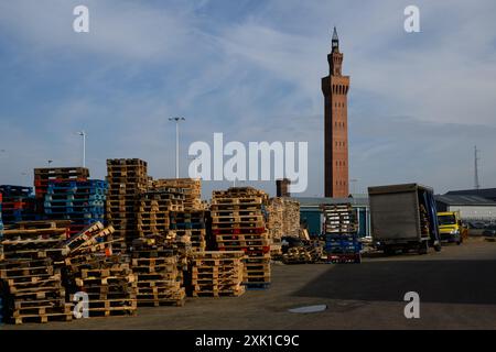 L'iconica Grimsby Dock Tower, vista dietro pile di pallet di legno vuoti. Situata nel nord-est del Lincolnshire, questa città storica aveva una fiorente industria della pesca, ma con l'industria della pesca in gran parte scomparsa, la zona ora soffre di privazione e abbandono. Mentre il Regno Unito si candida alle elezioni generali, il voto in queste roccaforti del "muro rosso” sarà un fattore critico per il risultato elettorale. ©Justin Griffiths-Williams 00442085339882 00447850053473 Foto Stock