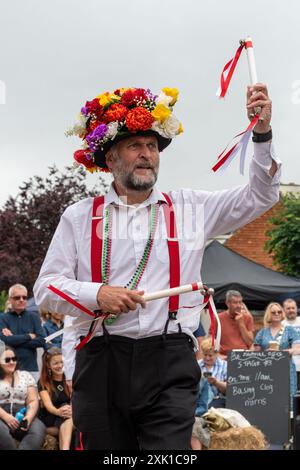 Overton Sheep Fair il 20 luglio 2024. Il tradizionale evento quadriennale si è svolto nel villaggio di Overton, Inghilterra, nel Regno Unito, nell'Hampshire, a partire da una pecora che ha guidato lungo la strada. C'erano molte bancarelle e intrattenimenti, tra cui balli Morris e una varietà di spettacoli di musica dal vivo. Nella foto: I ballerini Basingclog Morris intrattenono la folla nell'arena nel centro del villaggio Foto Stock