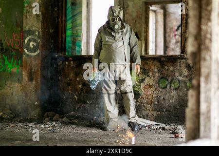 Una persona in tuta militare resistente agli agenti chimici OP1 su uno sfondo di rovine. Foto Stock