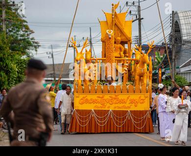 Un ufficiale di polizia tailandese è in guardia durante la processione delle candele per mostrare rispetto e devozione al buddismo e per preservare il loro patrimonio culturale. La tradizione della Candle Parade nel distretto di Mueang chi Sub, nel distretto di Mueang, nella provincia di Lamphun è un evento significativo durante il periodo della Quaresima buddista. Gli abitanti del villaggio si riunirono per creare grandi candele e sfilarle al tempio come atto di devozione e per preservare il loro patrimonio culturale locale. In tali tradizioni, è l'unico nel nord della Thailandia che è stato praticato per decenni. (Foto di Pongmanat Tasiri/SOPA Images/Sipa USA) Foto Stock