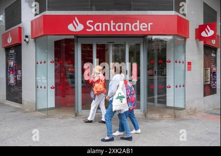 I pedoni passano davanti alla banca commerciale multinazionale spagnola e ai servizi finanziari, Santander Bank, in Spagna. Foto Stock