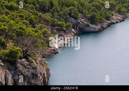 Bellissimo paesaggio, mare, montagne. Costa selvaggia, ripida, rocciosa. Rocce ricoperte di foresta verde. avvicinati all'acqua. Vista dall'alto. Foto Stock