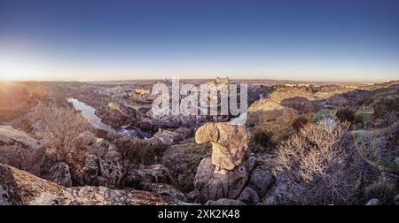 Un'immagine panoramica mozzafiato che cattura la storica città di Toledo, in Spagna, durante il tramonto i famosi monumenti della città, tra cui l'Alcazar e il Tagu Foto Stock