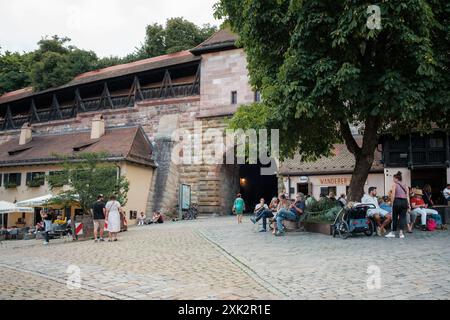 Vista di varie persone sedute all'esterno e che bevono birra vicino alla casa dell'Albrecht Dürer nella città tedesca di Nu Foto Stock