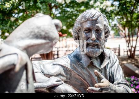 COLLEGE PARK, Maryland, Stati Uniti - il Jim Henson Memorial presso l'Università del Maryland presenta una statua in bronzo del famoso burattinaio con la sua famosa creazione, Kermit the Frog. Henson, un ex allievo dell'Università del Maryland, è raffigurato seduto su una panchina in una posa rilassata. Il memoriale, situato fuori dalla Adele H. Stamp Student Union, onora l'eredità creativa di Henson e il suo legame con l'università. Foto Stock