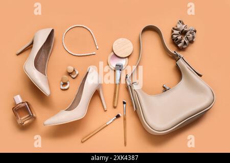 Scarpe, borse, accessori e spazzole per il trucco eleganti su sfondo marrone chiaro Foto Stock