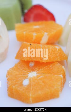 Piatto di frutta colorata con arance, banane, kiwi e fragole, ottimo spuntino sano Foto Stock