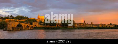 Un'ampia immagine panoramica 3:1 di una serata al tramonto con un arcobaleno e il Pont Saint-Bénézet, meglio conosciuto come Pont d'Avignone, un residuo di un histori Foto Stock