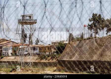 Un avamposto delle Nazioni Unite si trova all'interno della zona cuscinetto con le bandiere della Turchia e la cosiddetta "Repubblica turca di Cipro del Nord” visibile a destra, Nicosia, Cipro, il 20 luglio 2024. La linea verde (o zona cuscinetto) separa l’isola dal 1963, come misura iniziale per prevenire le ostilità tra greco-ciprioti e turco-ciprioti, ma dopo l'invasione turca del 1974, essa funziona de facto come confine tra la Repubblica di Cipro e la cosiddetta "Repubblica turca di Cipro del Nord”, che solo la Turchia riconosce come uno Stato legittimo. (Foto di Kostas Pikoulas/Sipa USA). Foto Stock