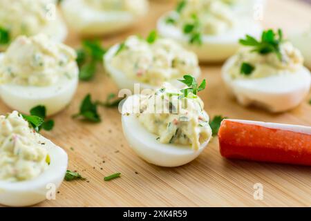 uova ripiene, uova diavolte su un tavolo di legno Foto Stock