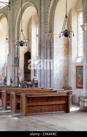 Interno del Priorato di Binham, con alcune delle panche, sculture delle panchine e le finestre Foto Stock