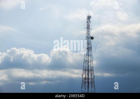 Torretta di segnalazione per telecomunicazioni 5G. Torre per telecomunicazioni su un cielo azzurro nuvoloso per lo sfondo, concetto di rete mobile tecnologica. Foto Stock