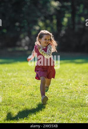 Una ragazza piccola e carina corre velocemente. Entra nel parco. Stile di vita attivo. movimento. Foto Stock