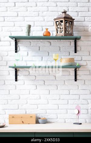 Piano cucina vuoto con ripiani verdi su muro in mattoni bianchi Foto Stock