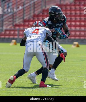 Darius Saint-Robinson (Helvetic Mercenaries, #4) versucht Joshua Flowers (Munich Ravens, #3) zu stoppen. Munich Ravens vs. Helvetic Mercenaries, calcio, European League of Football ELF, settimana 9, Saison 2024, 21.07.2024. Foto: Eibner Pressefoto/Heike Feiner Foto Stock