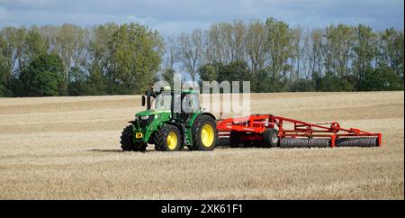 Trattore sul campo con impacchettamento del terreno King Roller nelle giornate di sole Foto Stock