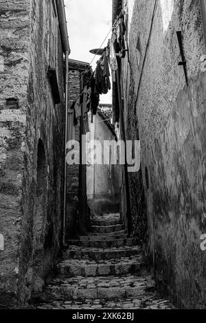 Un vicolo nel centro storico di Roccamandolfi con una serie di vestiti appesi per asciugare nell'aria Foto Stock