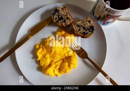 Uova strapazzate, muffin ai mirtilli, caffè nero. 2024 Giochi olimpici di Parigi gli utensili d'oro per la colazione vanno per l'oro Foto Stock