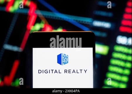 In questa illustrazione fotografica, il logo della società americana di investimento immobiliare Digital Realty (NYSE: DLR) è stato visualizzato su uno smartphone con un grafico dell'indice di borsa sullo sfondo. Foto Stock