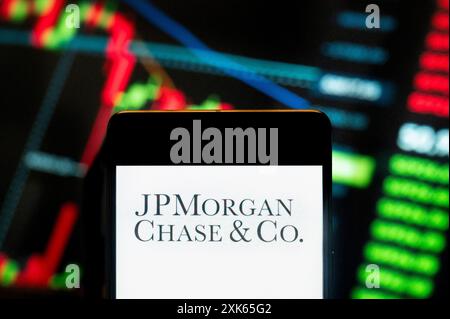 Cina. 21 luglio 2024. In questa illustrazione fotografica, il logo della multinazionale americana JPMorgan Chase & Co (JP Morgan Chase, NYSE: JPM) è stato visualizzato su uno smartphone con un grafico dell'indice di borsa economica sullo sfondo. (Foto di Budrul Chukrut/SOPA Images/Sipa USA) *** esclusivamente per notizie editoriali *** credito: SIPA USA/Alamy Live News Foto Stock