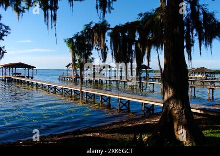 Il sole mattutino splende sul lago Waccamaw su alcuni moli e barche. Foto Stock