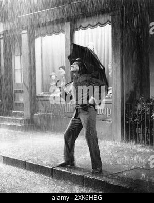 American Dancer, coreografo e attore GENE KELLY che esegue il numero del titolo in SINGIN' IN THE RAIN 1952 regista STANLEY DONEN Story di BETTY COMDEN e ADOLPH GREEN Music and Lyrics di NACIO HERB BROWN e ARTHUR FREED Costume Design WALTER PLUNKETT produttore ARTHUR FREED Metro Goldwyn Mayer Foto Stock