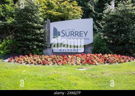 Benvenuto al cartello del Surrey con i fiori in piena fioritura sull'autostrada 10 a Surrey, British Columbia, Canada Foto Stock