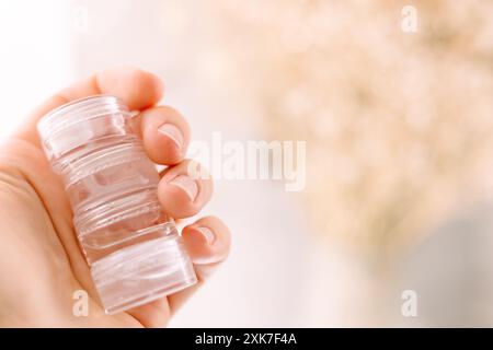 la mano della donna tiene i barattoli di cosmetici con delle creme Foto Stock