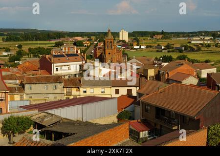 Astorga, Spagna - 3 giugno 2023: Astorga, Spains, tetti di tegole rosse e chiesetta sotto la calda luce del sole creano un tranquillo paesaggio urbano. Foto Stock