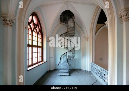 Vecchia scala a chiocciola in acciaio in una villa in stile gotico. Foto Stock