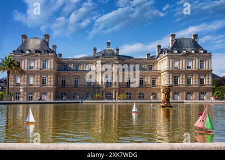 Il paesaggio urbano parigino - vista della piscina con barche a vela giocattolo galleggianti di fronte alla facciata sud del Palais de Luxembourg, Parigi, Francia Foto Stock