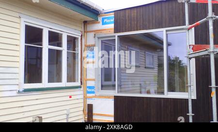 Una casa in legno degli anni '1950 con finestre e rivestimenti originali, con una nuova ala aggiunta, utilizzando il rivestimento Abodo e finestre a doppi vetri Foto Stock