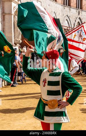 Un giovane dell'Oca (Oca) bandiera Contrada sventolando in Piazza del campo durante i quattro giorni di Palio, Siena, Toscana, Italia. Foto Stock