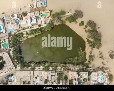 Huacachina, Perù: Foto dall'alto verso il basso dell'oasi di Huacachina costeggiata da hotel nel deserto di sabbia vicino a Ica, in Perù, nel Sud America. Foto Stock