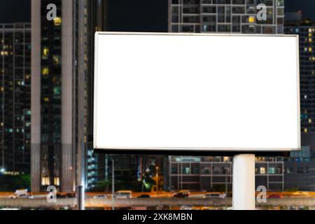 Cartellone bianco bianco bianco con sfondo urbano di Bangkok di notte. Poster pubblicitario di strada, mock-up. Vista frontale. Il concetto di marketing c Foto Stock