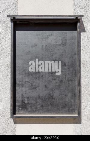 Mockup per espositori in legno per pubblicità o poster appesi alla parete. Tabellone nero alla luce del sole Foto Stock