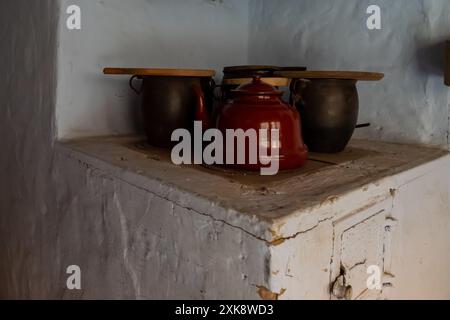 Vecchie pentole di argilla su una storica stufa a legna nello storico cottage polacco Foto Stock