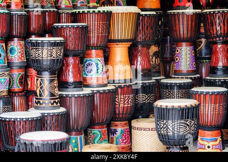 File di tamburi colorati in legno di djembe al negozio di souvenir Foto Stock