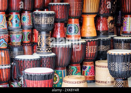 File colorate di tamburi in legno di djembe al negozio di souvenir Foto Stock