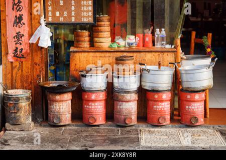 Fila di pentole da cucina e cesti Dim Sum all'esterno del ristorante Foto Stock