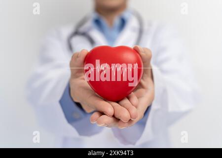 Medico che tiene in mano la forma del cuore rosso e l'icona moderna della rete medica collegata al concetto di rete di tecnologia medica a schermo virtuale. Medico e pacca Foto Stock