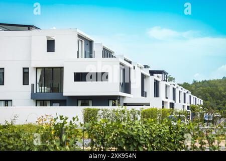 Nuovi edifici di appartamenti White a Phuket in Thailandia. Moderna architettura residenziale con alberi verdi e recinzione. Appartamento duplex. Appartamento con giardino Foto Stock