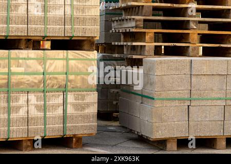 Lastre di pietra per riparazioni stradali impilate su un pallet di legno. Foto Stock