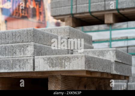 Lastre di pietra per riparazioni stradali impilate su un pallet di legno. Foto Stock