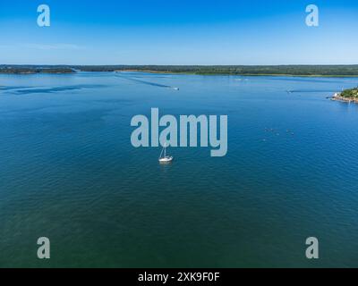 Una barca a vela nell'arcipelago di Stoccolma con le sue numerose isole, kayak e motoscafi di passaggio. Estate. Tipici paesaggi svedesi Foto Stock
