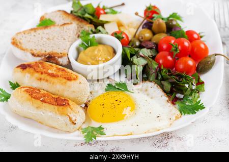 Uova fritte, salsiccia di pollo fatta in casa, toast e insalata fresca. Keto, colazione paleo. Foto Stock