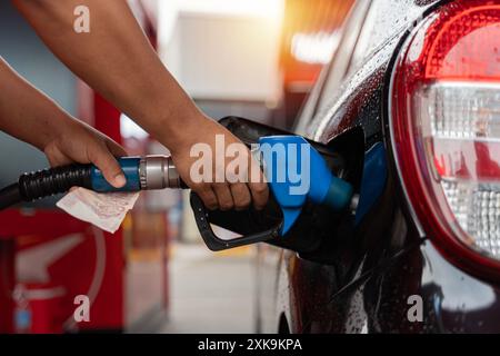 Il rifornimento di carburante della macchina in corrispondenza di una stazione di rifornimento della pompa del combustibile. Man mano driver di riempimento e di pompaggio olio di benzina la vettura con il carburante alla stazione di rifornimento. Il rifornimento di carburante per auto Foto Stock