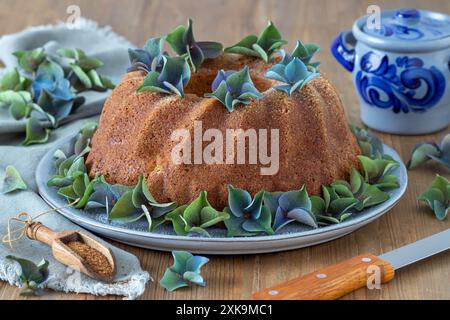 torta gugelhupf con farina integrale su un piatto decorato con ortensie in fiore Foto Stock