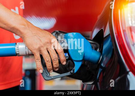 Il rifornimento di carburante della macchina in corrispondenza di una stazione di rifornimento della pompa del combustibile. Man mano driver di riempimento e di pompaggio olio di benzina la vettura con il carburante alla stazione di rifornimento. Il rifornimento di carburante per auto Foto Stock