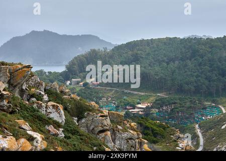 La fotografia panoramica ad alto angolo cattura il percorso tortuoso che conduce al faro e all'area campeggio sulle isole Cies in Galizia, Spagna. Il Foto Stock